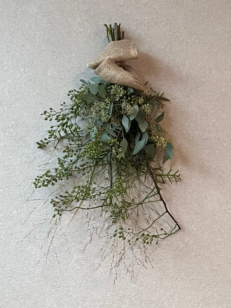 グレーの壁に飾られたフレッシュグリーンのスワッグ