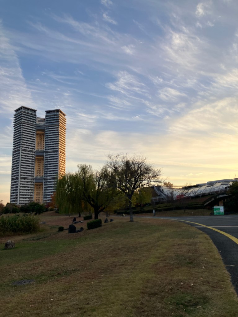 マンションの背後に綺麗な夕暮れの空と公園
